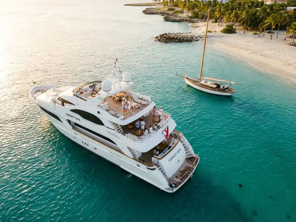 Luxury white yacht with passengers enjoying drinks anchored in turquoise Caribbean waters near Aruba's coastline