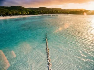 Luxury yacht anchored in turquoise Caribbean bay with crystal-clear waters and tropical Aruba coastline at golden hour